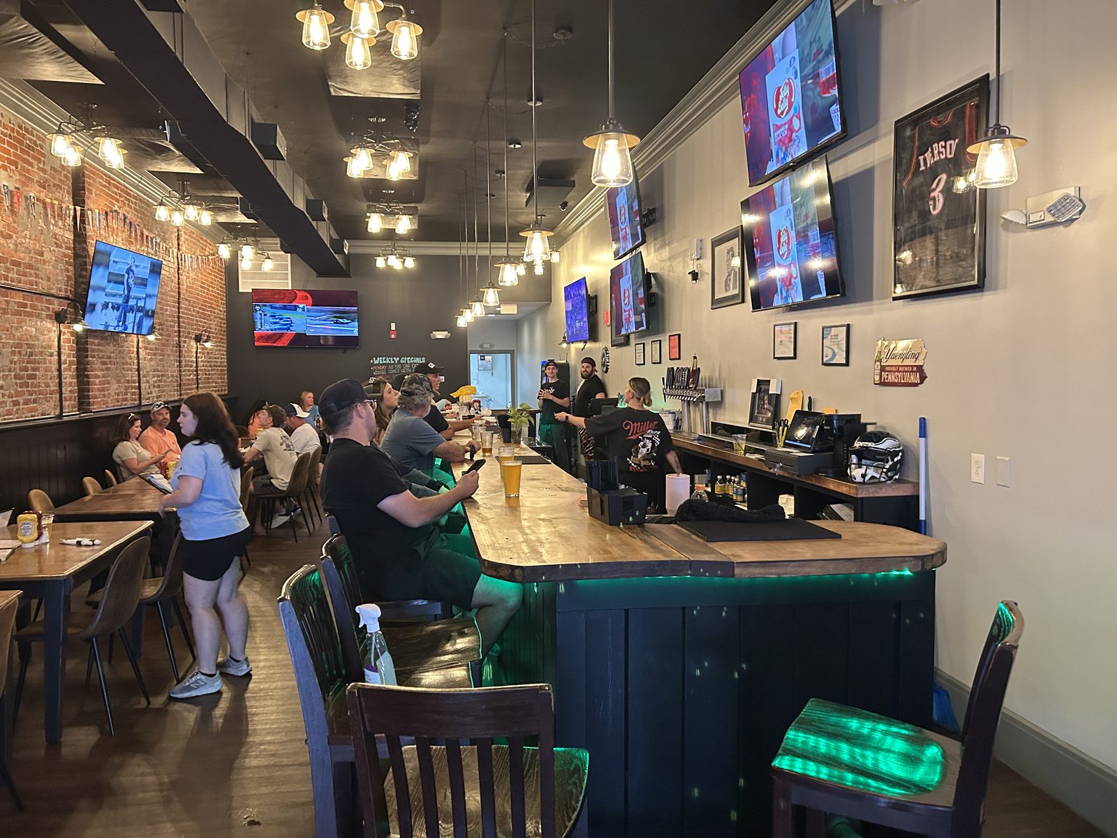 Inside Spectators sports bar in Pottstown, PA, with big-screen TVs and bar seating