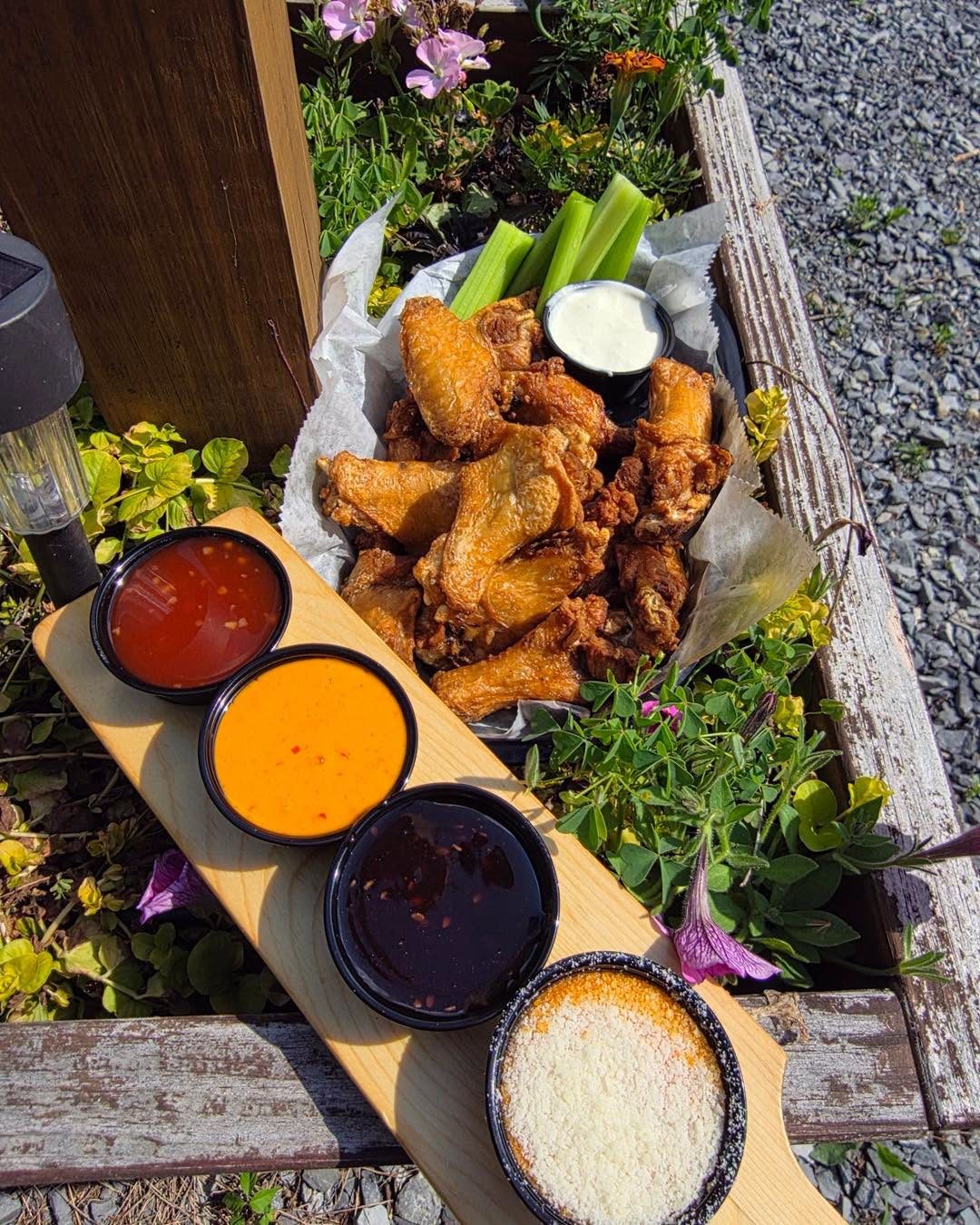 Basket of crispy wings with a flight of dipping sauces at Spectators in Pottstown, PA